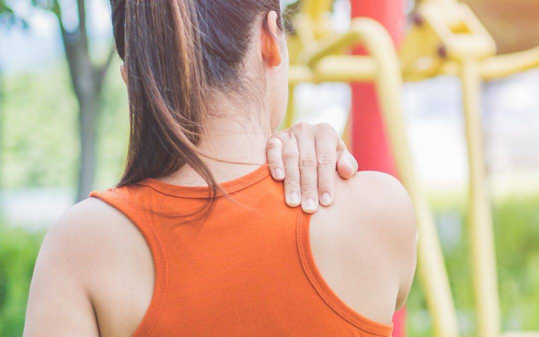 Young asian woman feel pain on her neck and shoulder while exerc