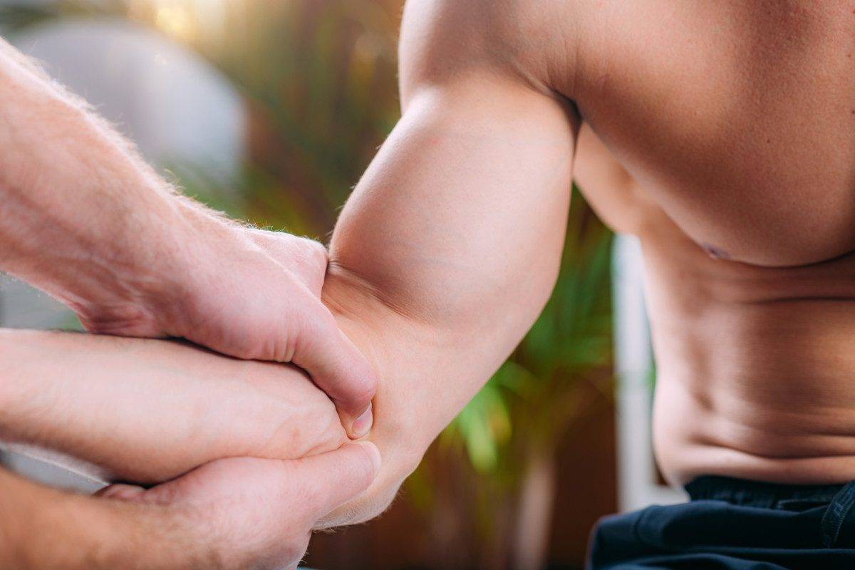 Chiropractic Adjustment. Therapist doing manual therapy manipulation technique on an elbow. Tennis elbow injury.