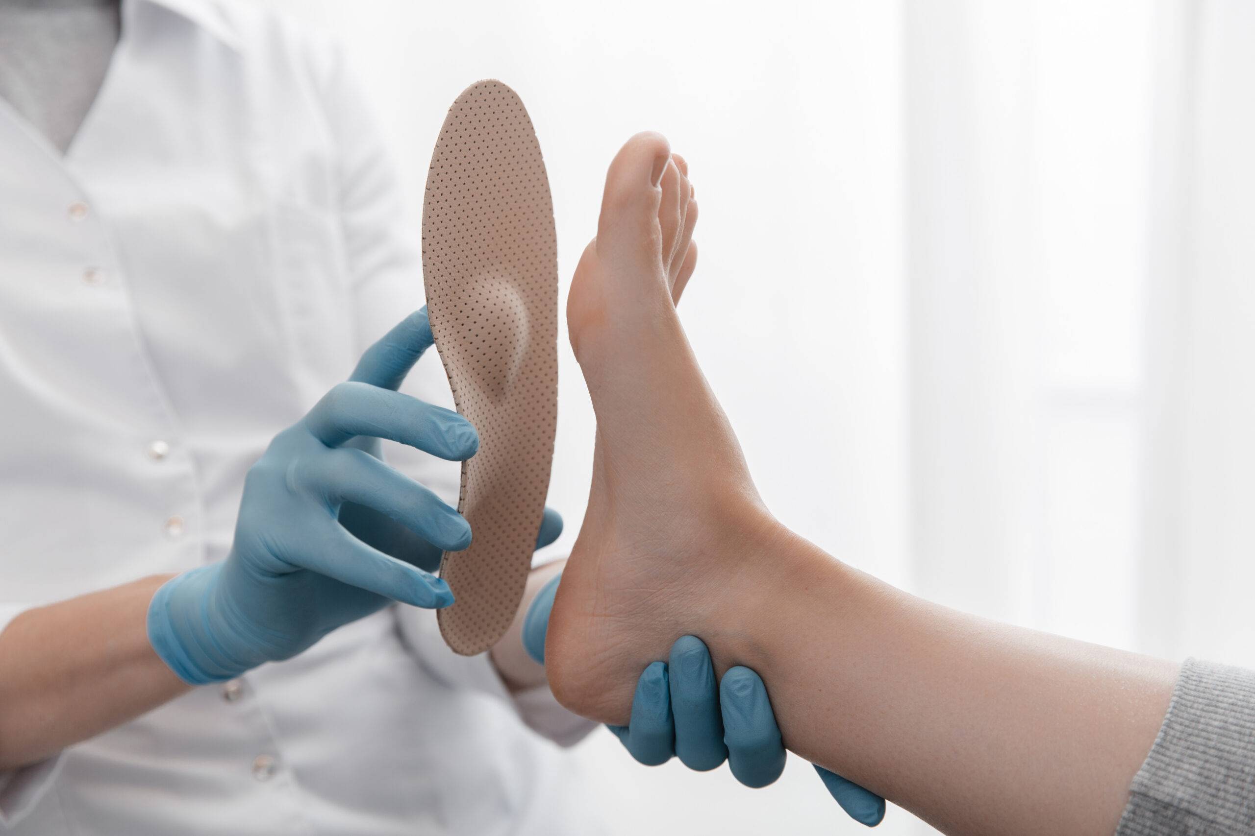 Woman rolling spiked ball under her feet in physical therapy